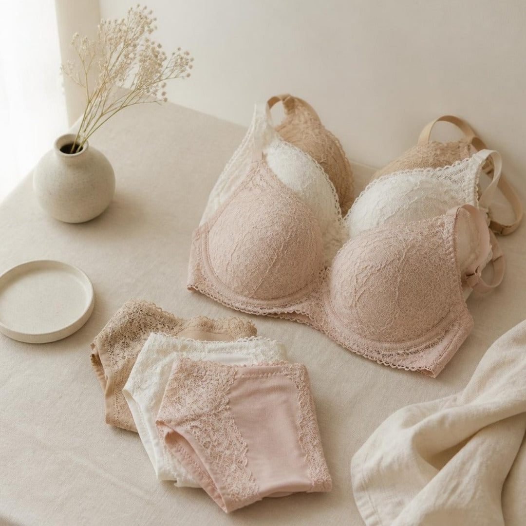 Folded lace bras and briefs in nude, blush and ivory on cream linen